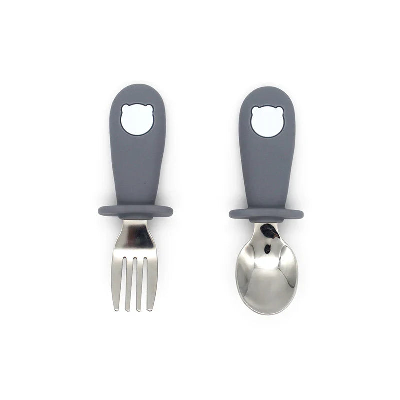 Healthy eating toddler cutlery & tableware: silicone plate, bowl, spoon, and stainless steel fork.