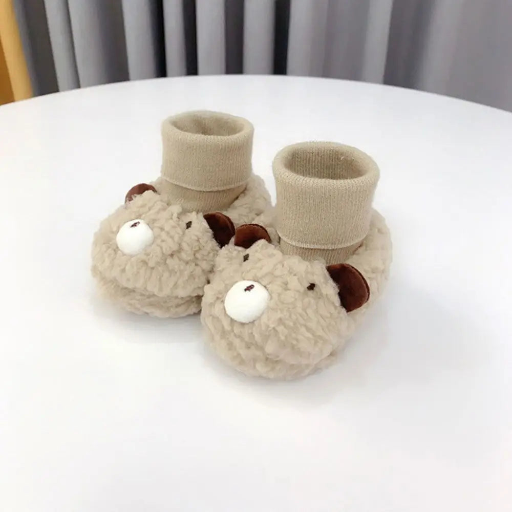 Pair of brown baby bear fleece slippers, perfect infant booties for keeping little feet warm and snug.