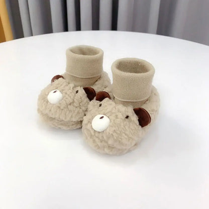 Pair of brown baby bear fleece slippers, perfect infant booties for keeping little feet warm and snug.