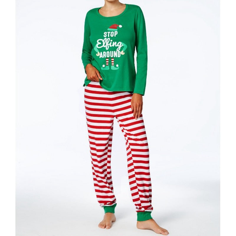 Toddler in matching family Christmas pajamas, happily playing. Holiday sleepwear.
