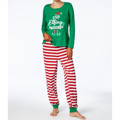 Toddler in matching family Christmas pajamas, happily playing. Holiday sleepwear.