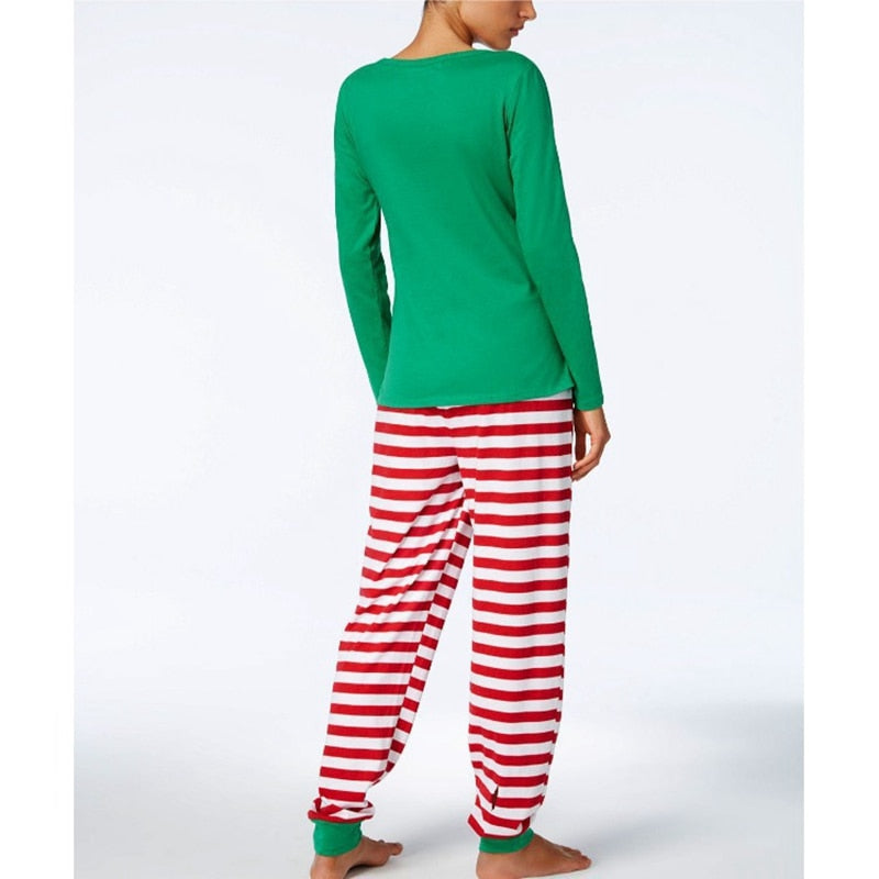 Parents and baby wearing coordinating Christmas themed pajamas, celebrating the holidays.