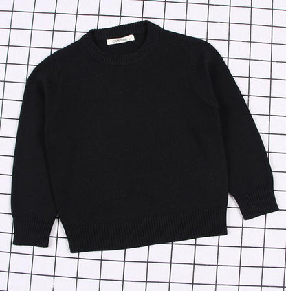 Close-up of the ribbed cuffs and hem on a practical kids cable knit pullover sweater, 100% cozy.