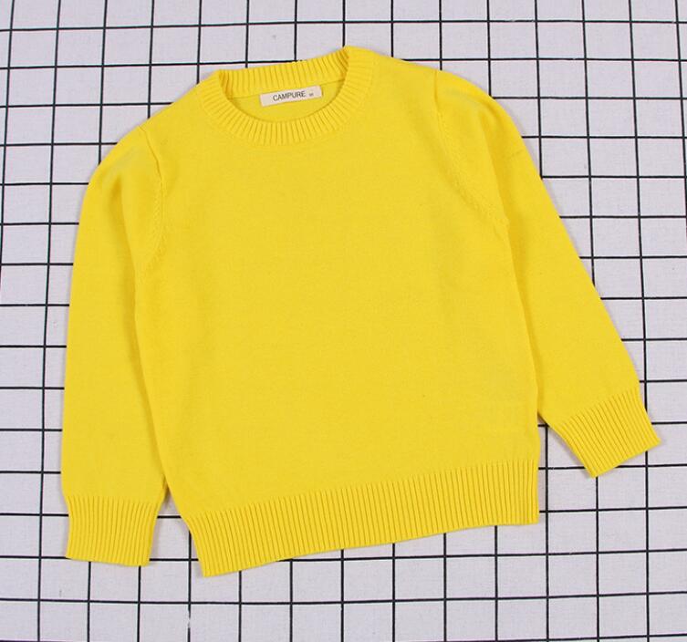 A stack of colorful cable knit pullover sweaters for kids, showcasing variety in baby apparel.