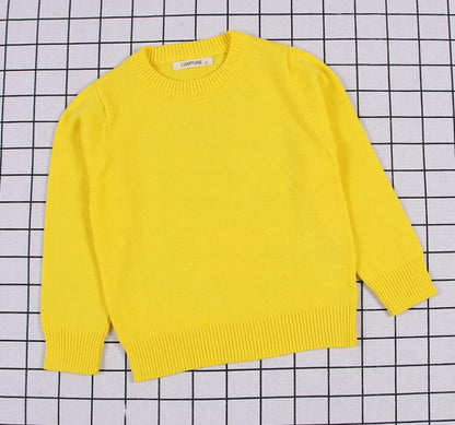 A stack of colorful cable knit pullover sweaters for kids, showcasing variety in baby apparel.