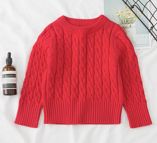 Stylish child modeling a comfy cable knit pullover sweater, ready for outdoor play in winter.