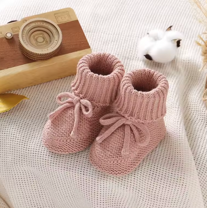 Baby winter gear: adorable knitted booties in a neutral tone, a thoughtful baby shower gift.