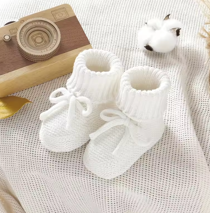 Infant footwear: comfortable and soft knitted baby booties, essential for newborn warmth.