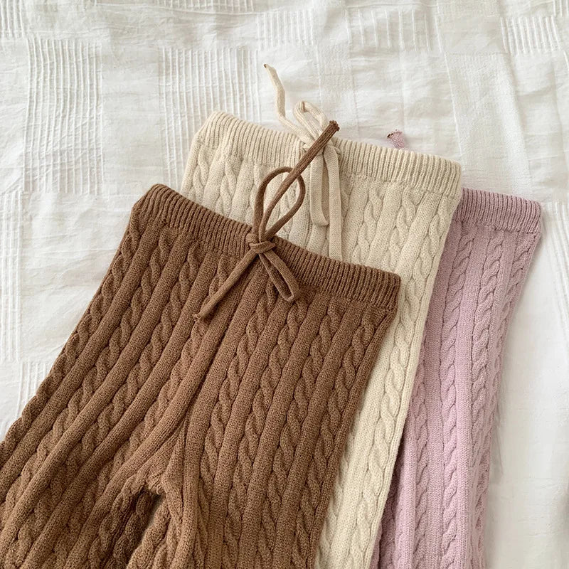 Stylish girls' knitted outfit, sweater and pants, designed for comfortable cool weather.