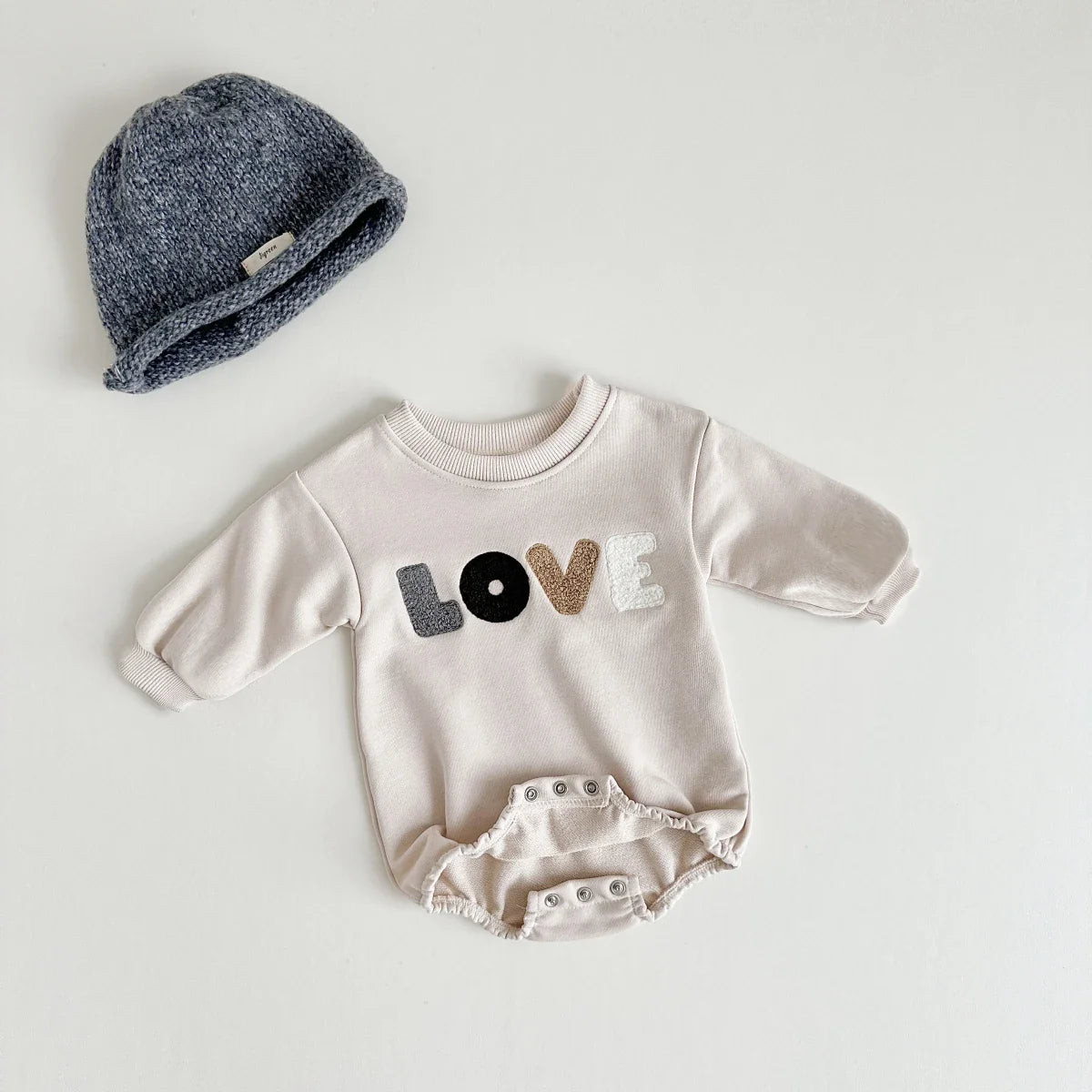 Comfortable cotton blend baby romper in cream, with 'love' embroidery for spring and autumn.
