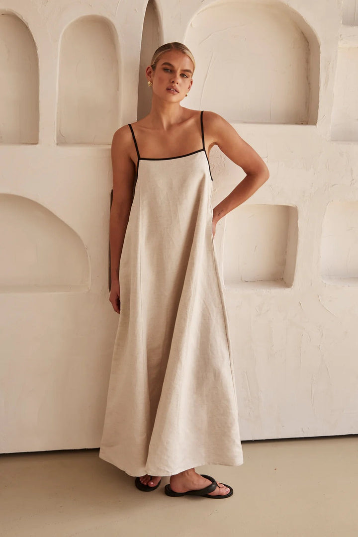Flowy women's cream maxi dress with a square neck, spaghetti straps & contrast trim, perfect for summer resort.