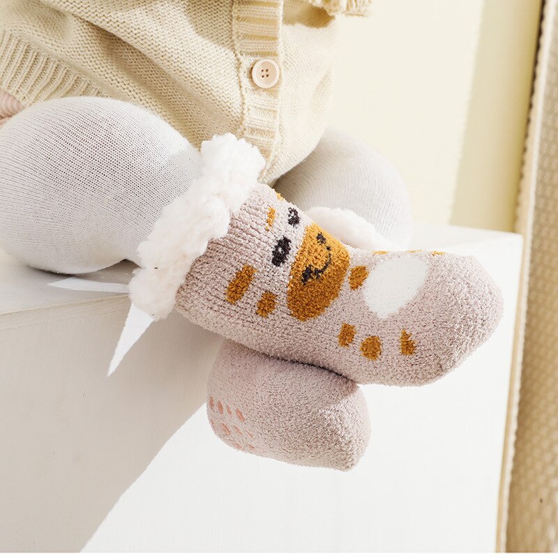 Close-up of a baby's feet in soft, warm grey terry anti-slip socks, ideal for winter newborns.