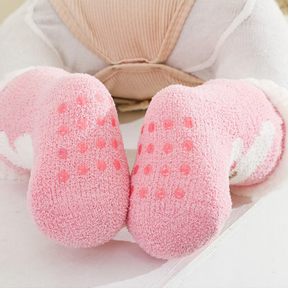 Parents hand holding a baby's foot wearing a soft, warm terry anti-slip sock, winter baby clothing.