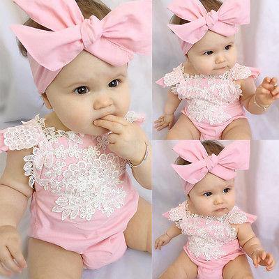 Cute baby girl in a pink lace romper with matching headband, perfect for infant fashion.