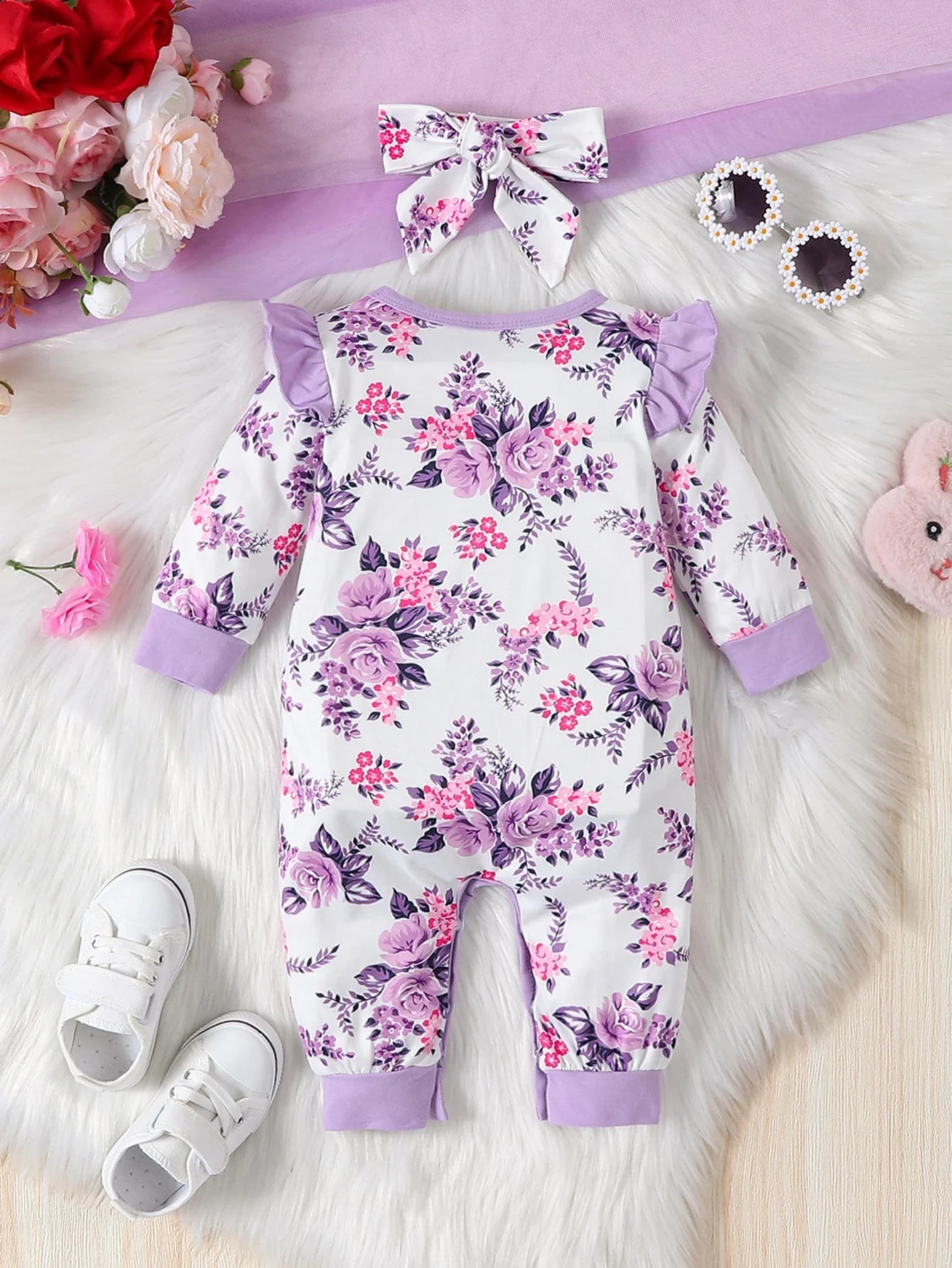 Front view of a baby girl's floral romper and coordinating bow headband set, sweet infant clothing.