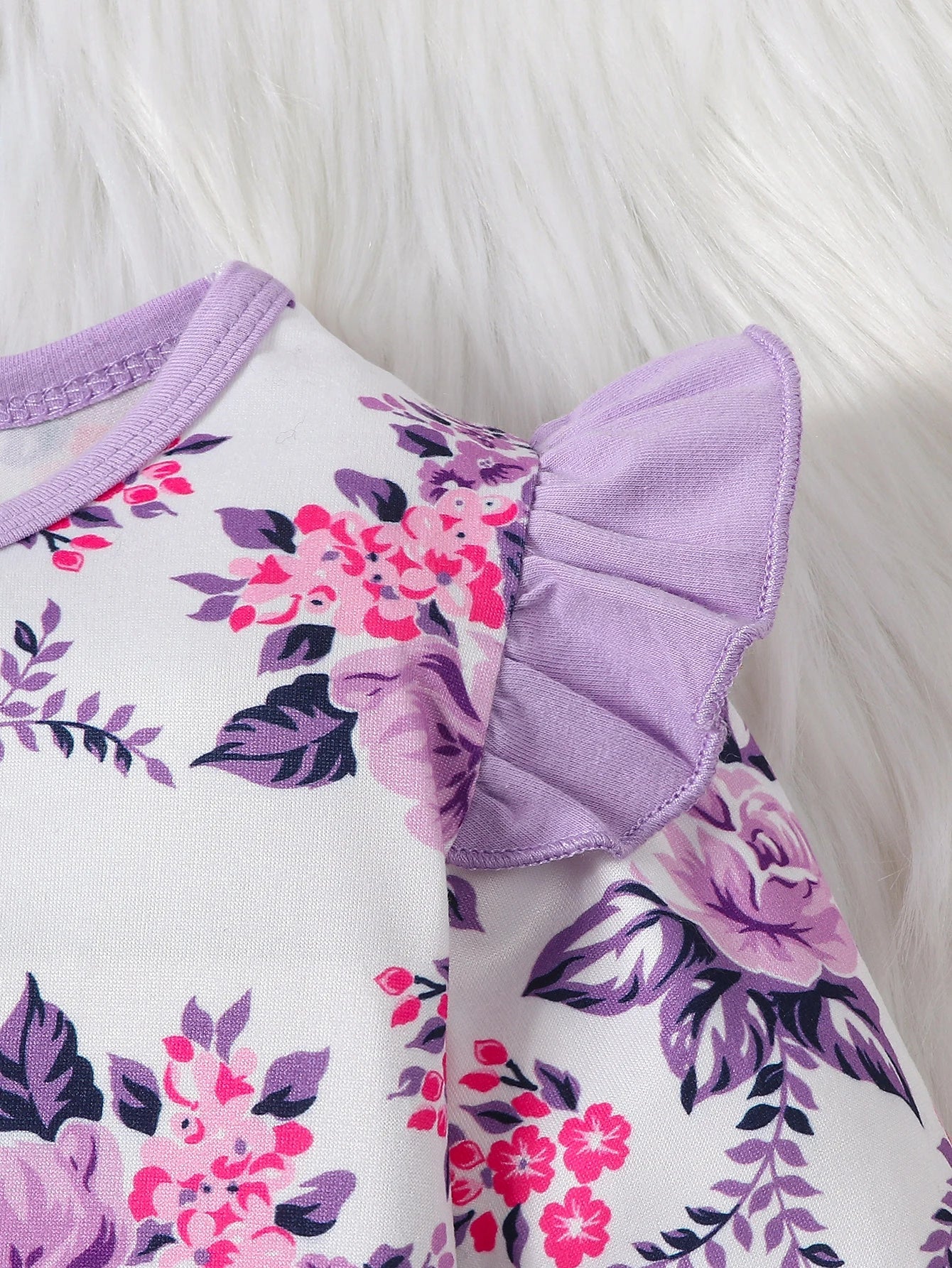 Adorable baby girl modeling a comfy floral romper and stylish bow headband, ideal baby gift.