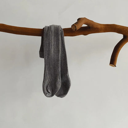 Baby girl's outfit featuring white cotton knit pantyhose, a staple in children's apparel.