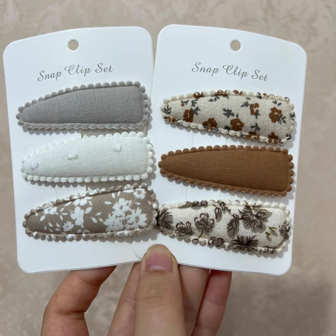 Vibrant flower print hair clips for baby girls, adding a sweet touch to any toddler or infant outfit.