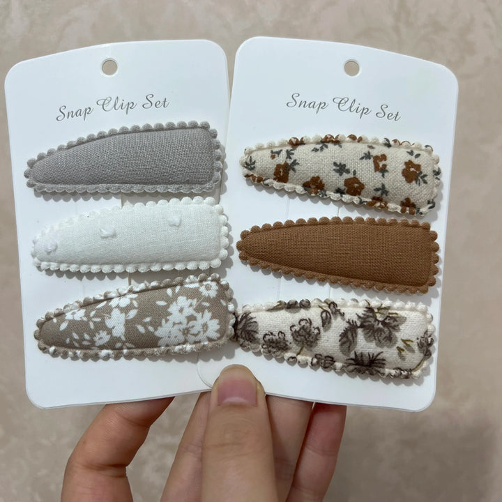 Vibrant flower print hair clips for baby girls, adding a sweet touch to any toddler or infant outfit.