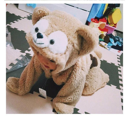 Happy toddler playing in a warm, cute teddy bear winter jumpsuit, a cozy hooded outfit for infants.