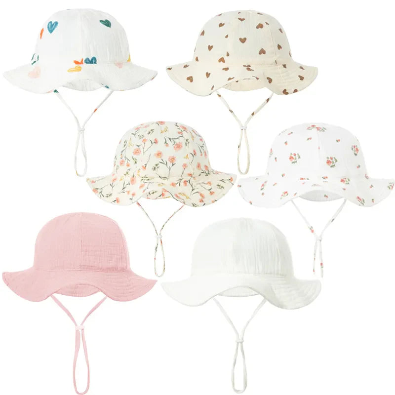 Cute baby wearing blue cotton sun hat with chin strap, perfect for outdoor sun protection.