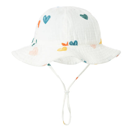 Smiling baby wearing a striped cotton sun hat, excellent for sunny day adventures and protection.