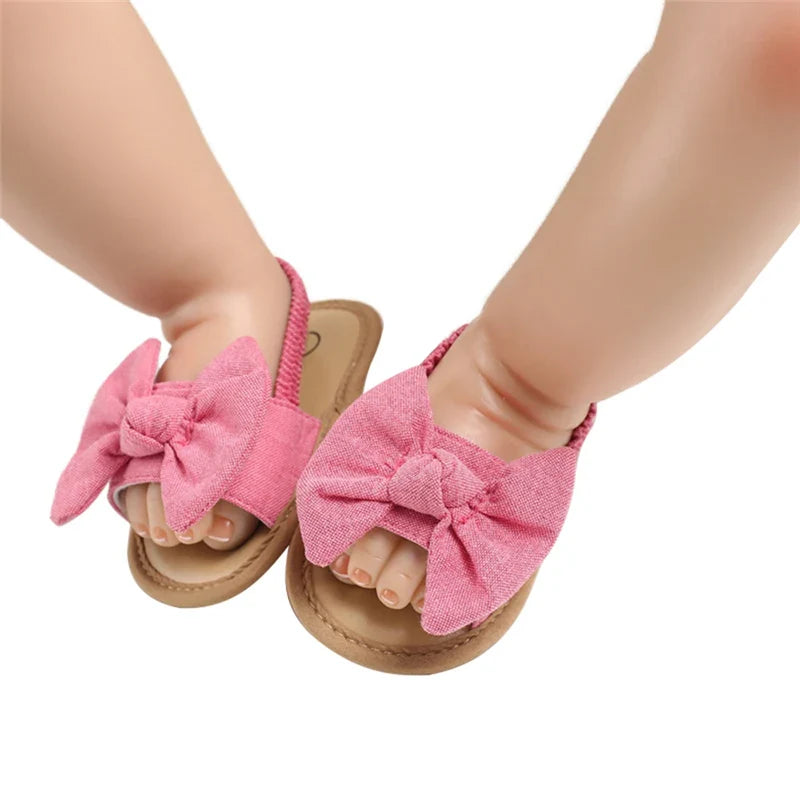 Cotton baby girl sandals in red with a flexible cork sole, designed as comfortable first walking shoes.