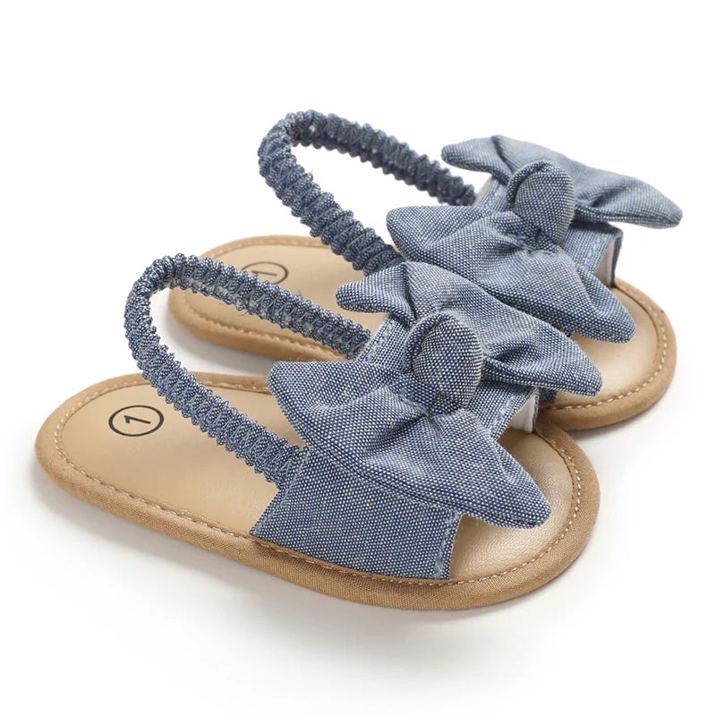 Close-up of a baby boy's blue cork sole sandal, showcasing soft cotton and comfortable design.