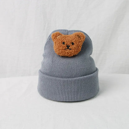 Soft, stretchable knitted baby hat with a fun cartoon bear motif, unisex appeal.