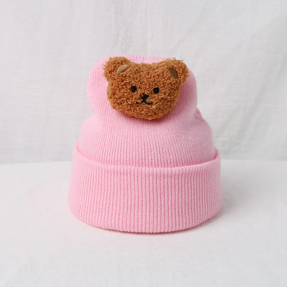 Detailed shot of the knitted texture and bear face on a warm baby winter hat.