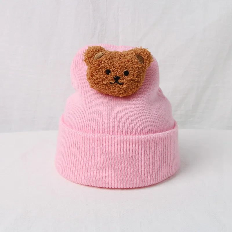 Plush knitted baby hat with an endearing bear design, great for winter activities.