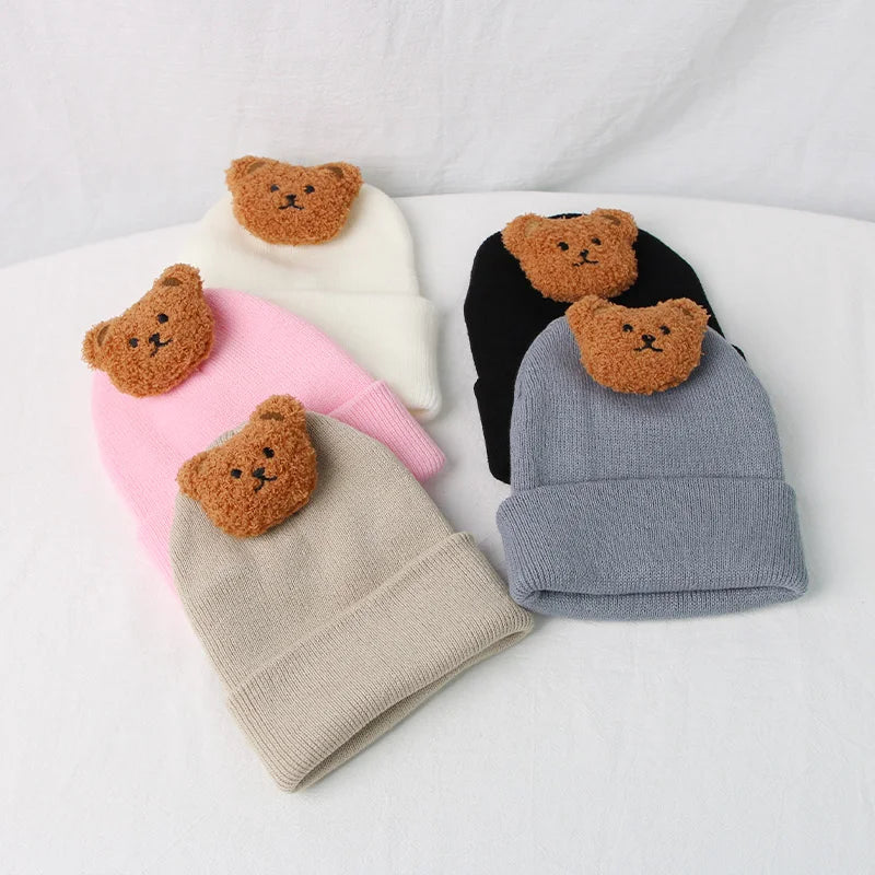 Close-up of a knitted baby hat featuring a playful cartoon bear design.