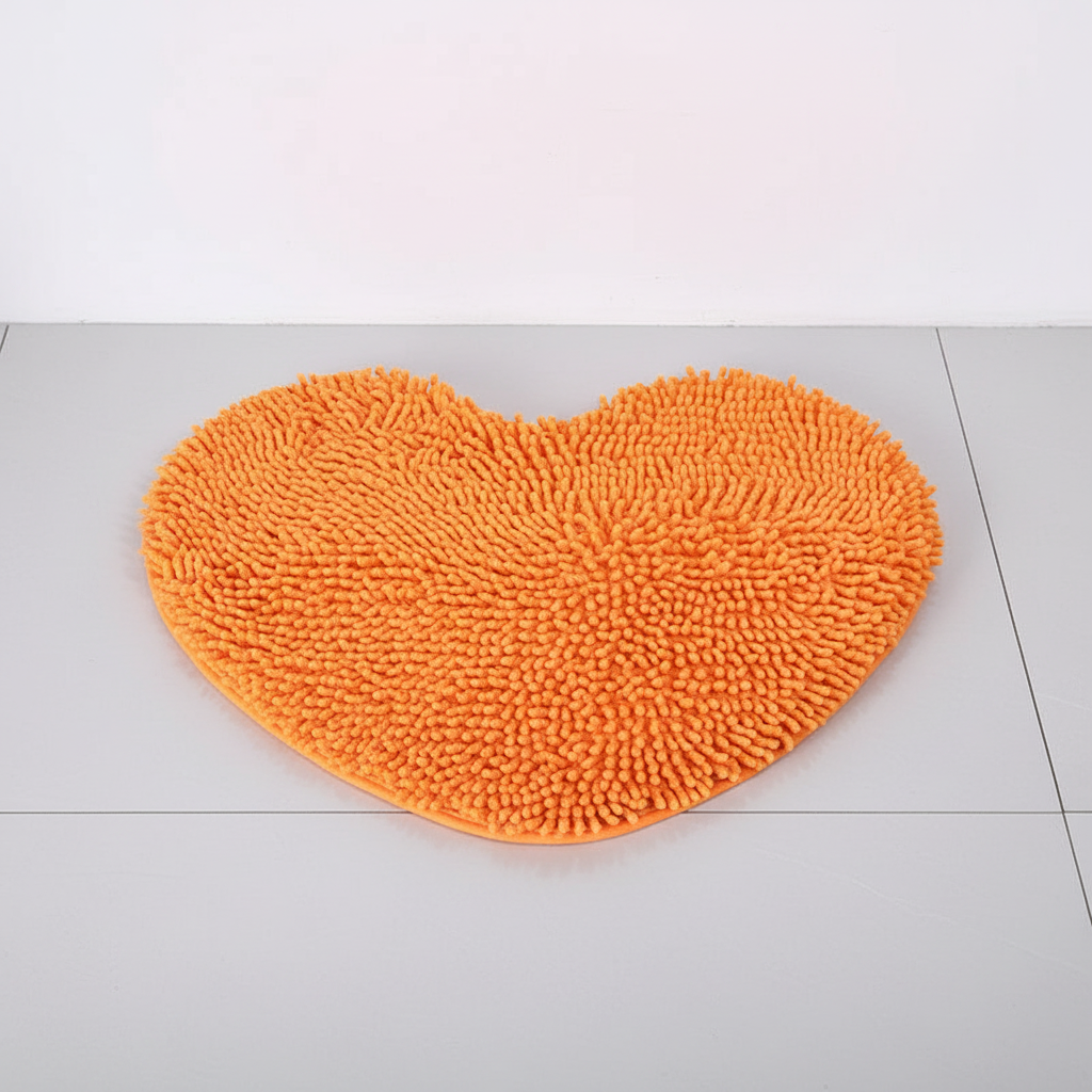 Absorbent heart-shaped microfiber bath mat with anti-slip backing for bathroom safety & comfort.