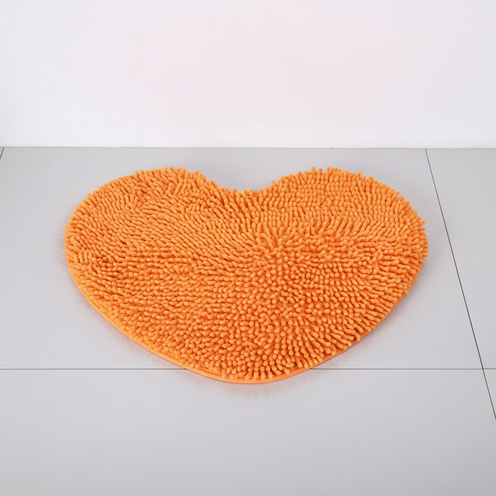 Absorbent heart-shaped microfiber bath mat with anti-slip backing for bathroom safety & comfort.