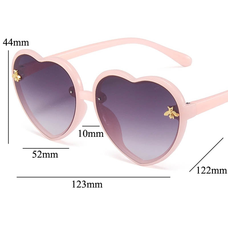 Close-up of heart-shaped blue sunglasses for girls, showcasing design & UV protection for kids' summer style