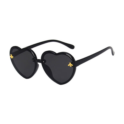 Assortment of colorful heart-shaped sunglasses for girls, featuring various hues and UV protection for kids