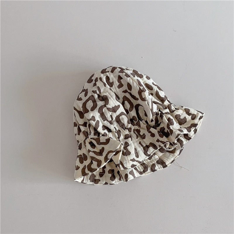 Newborn wearing a gentle ivory cotton beanie, emphasizing its softness and infant-safe design.