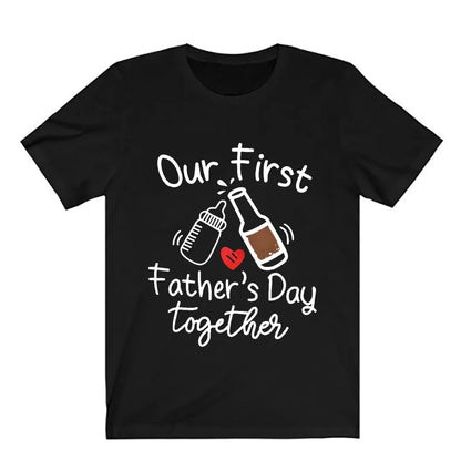 Happy father and baby in matching 'First Father's Day' daddy and me apparel, outdoor setting.
