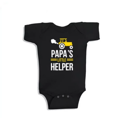 Dad and son in matching black 'Papa' and 'Little Helper' cotton blend t-shirts, laughing.