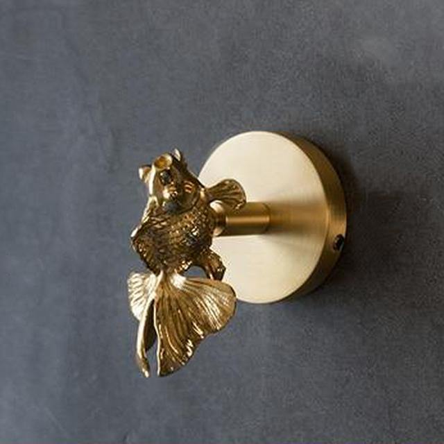 Polished gold animal coat hook, a luxury decorative wall accessory for home organization.