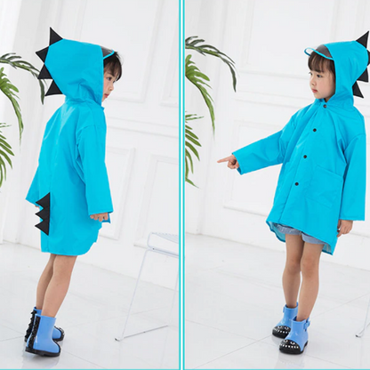 Young boy in a green dinosaur raincoat with hood, standing under an umbrella, polyester raincoat protection