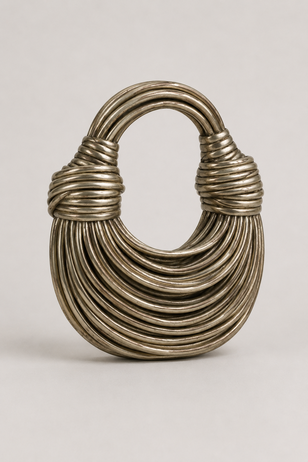 Stylish black crescent shoulder bag featuring a unique sculptural loop handle. Modern women's elegant everyday accessory.