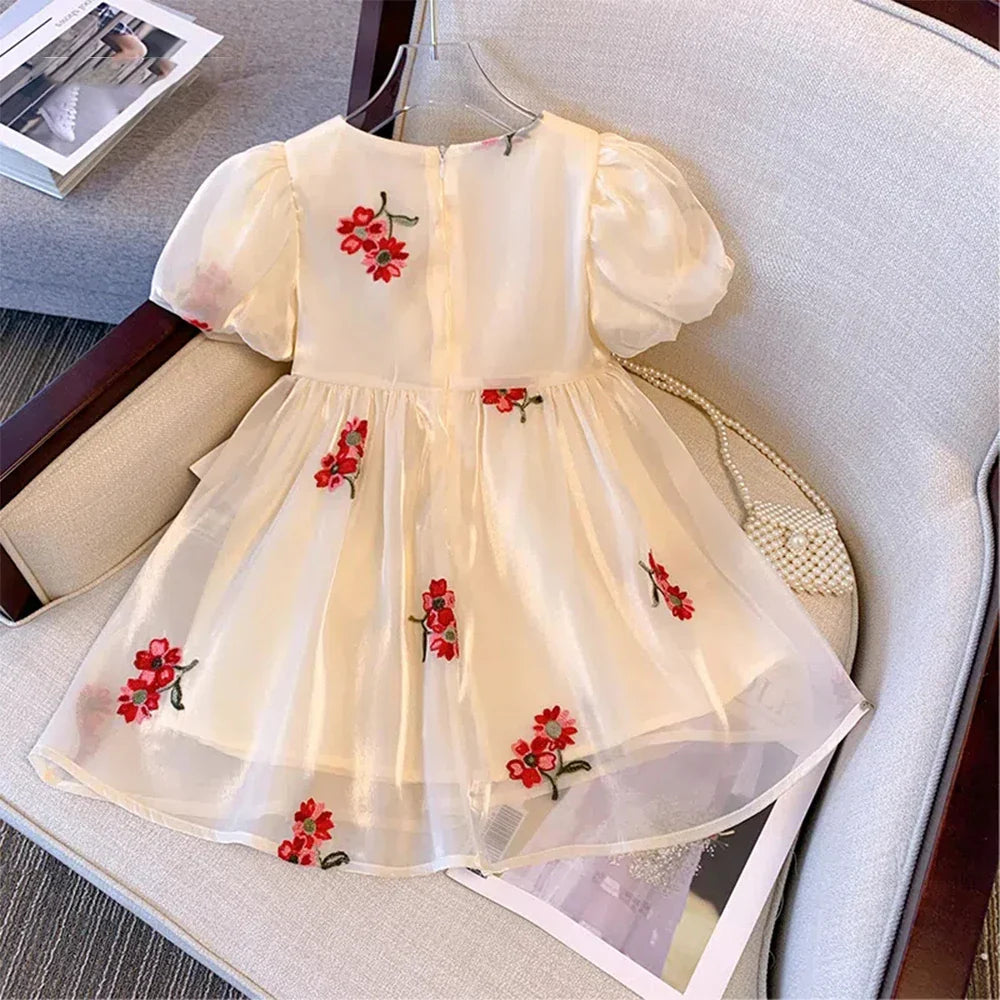 Back view of the elegant beige summer princess dress for toddlers, showcasing its full skirt and ribbon detail.
