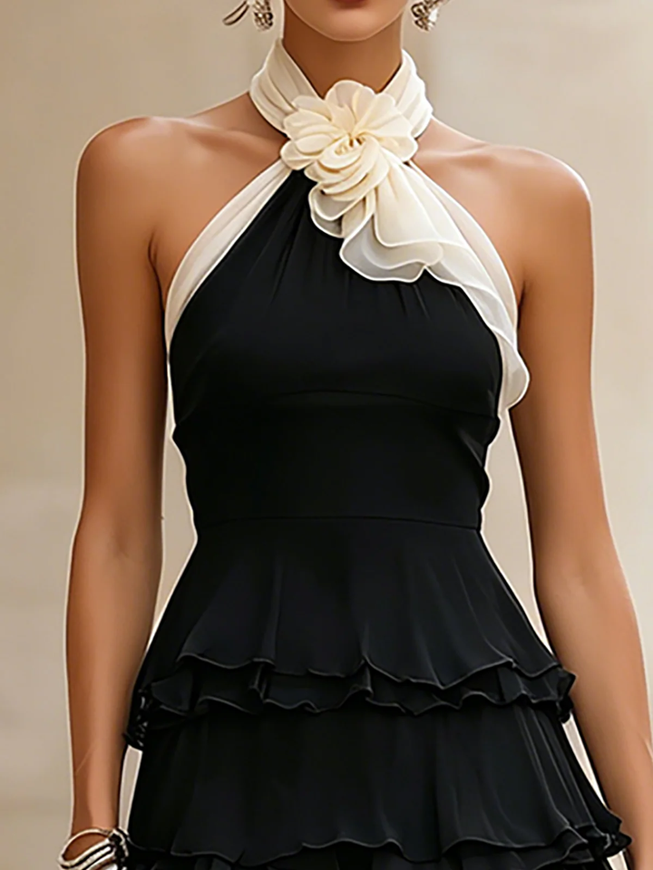 Women's black halter cocktail mini dress. Features delicate rosette & chic ruffles, ideal for evening parties.