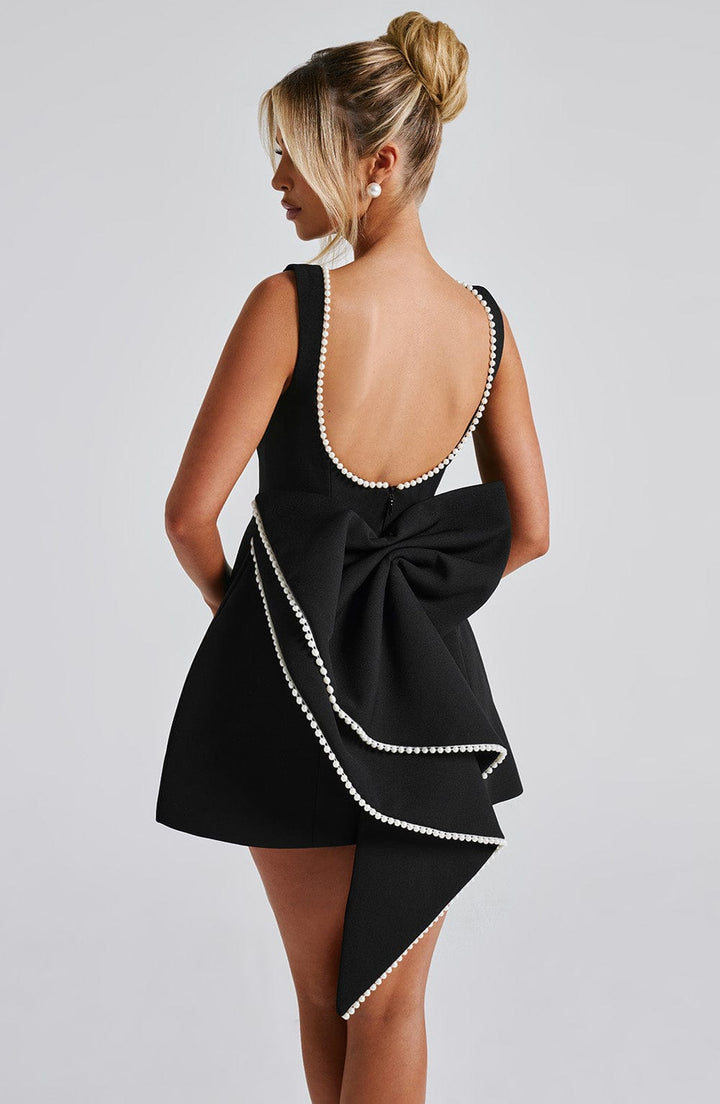 Fashionable black tailored mini dress, sleeveless with a confident, structured silhouette. A chic party or evening dress.