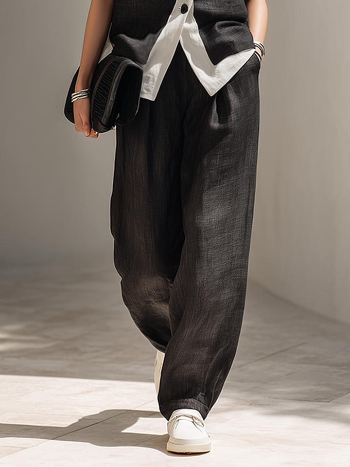 Women's elegant black tailored set, including a sleeveless top and flowing wide-leg pants, suitable for formal occasions.