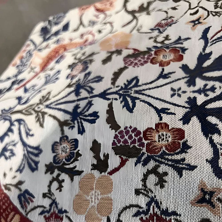Elegant jacquard table runner, intricate floral and bird motif, adding a touch of vintage charm.