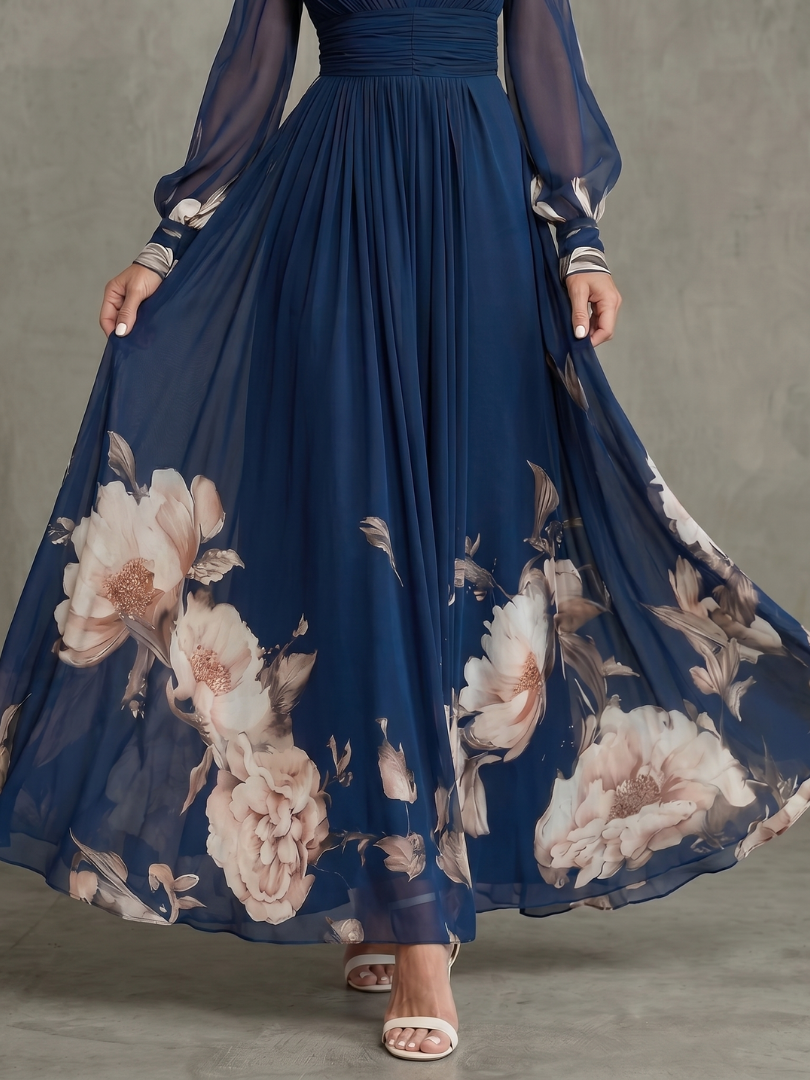 Woman models an elegant navy V-neck pleated maxi dress with sheer sleeves, showing its flowy design and sophistication.