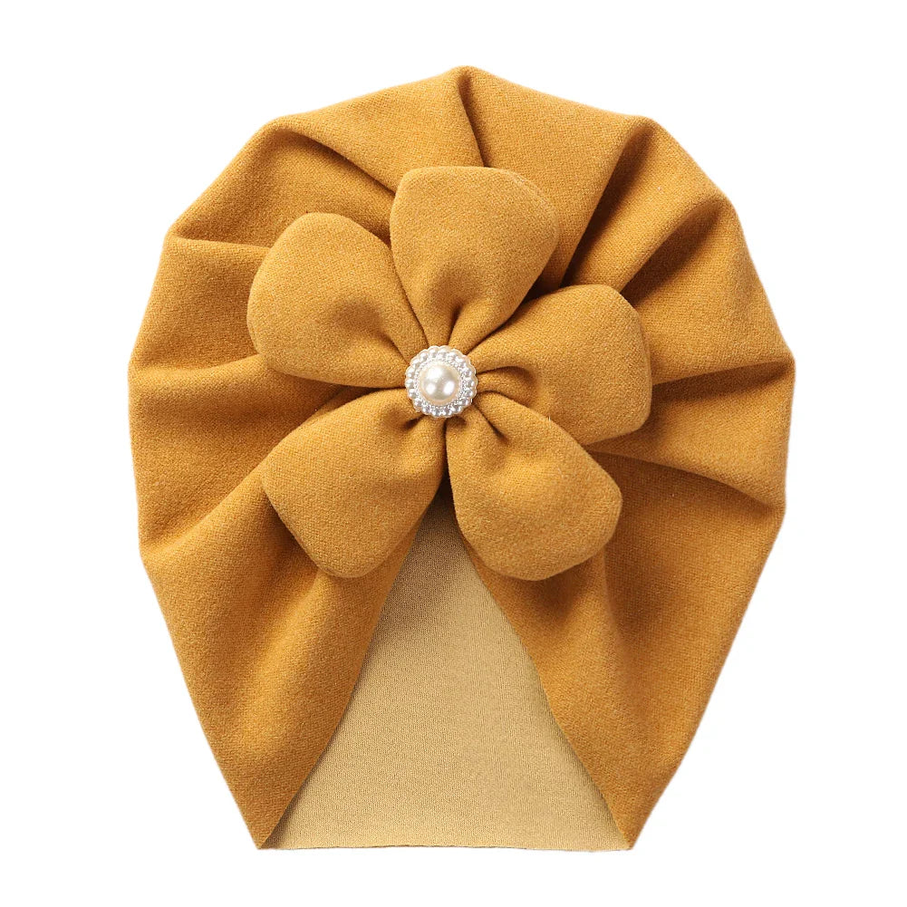 Side view of a baby turban hat showcasing the elegant pearl embellishment beautifully.
