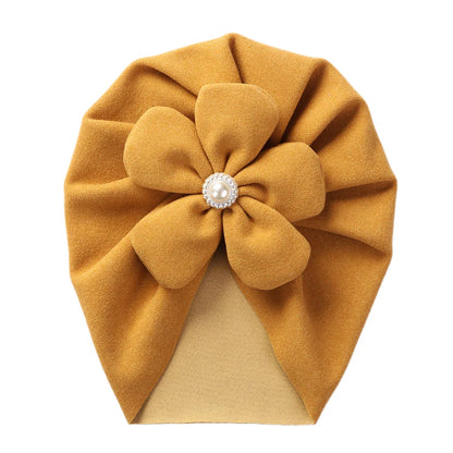 Side view of a baby turban hat showcasing the elegant pearl embellishment beautifully.